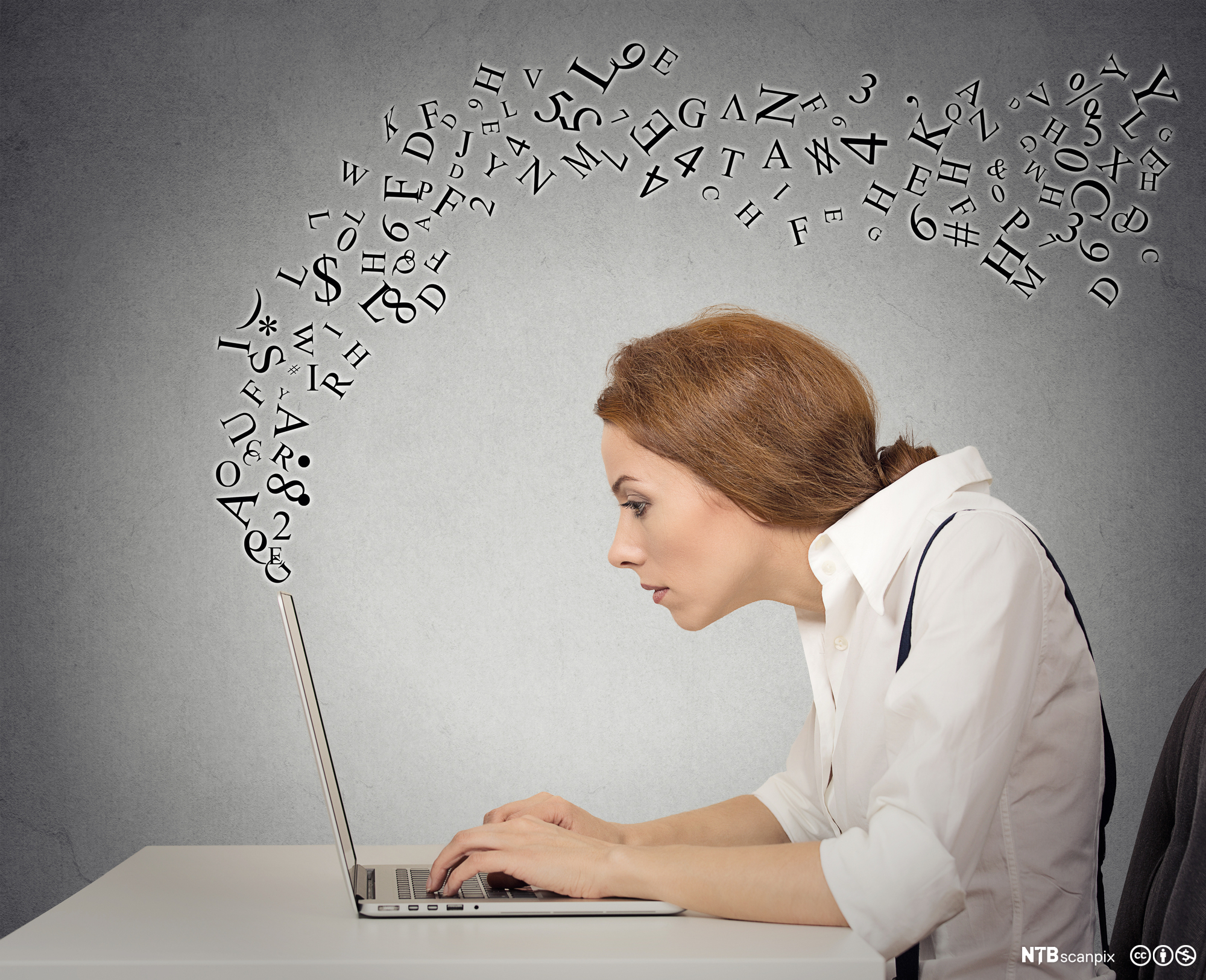 A woman is typing on her computer while letters fly around her. Photo.