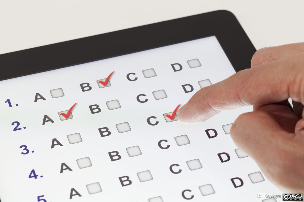 Foto av ei hånd som setter hake ved ulike svaralternativer på en nettbrettskjerm.