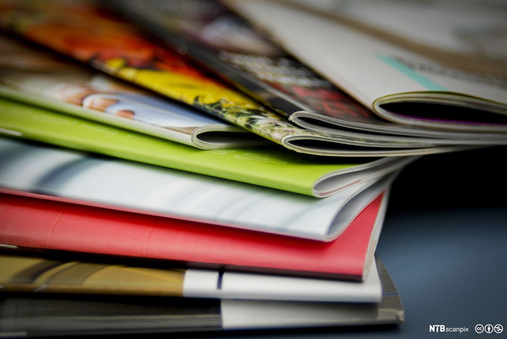 Flere brosjyrer som ligger oppå hverandre, i ulike farger. Foto.
