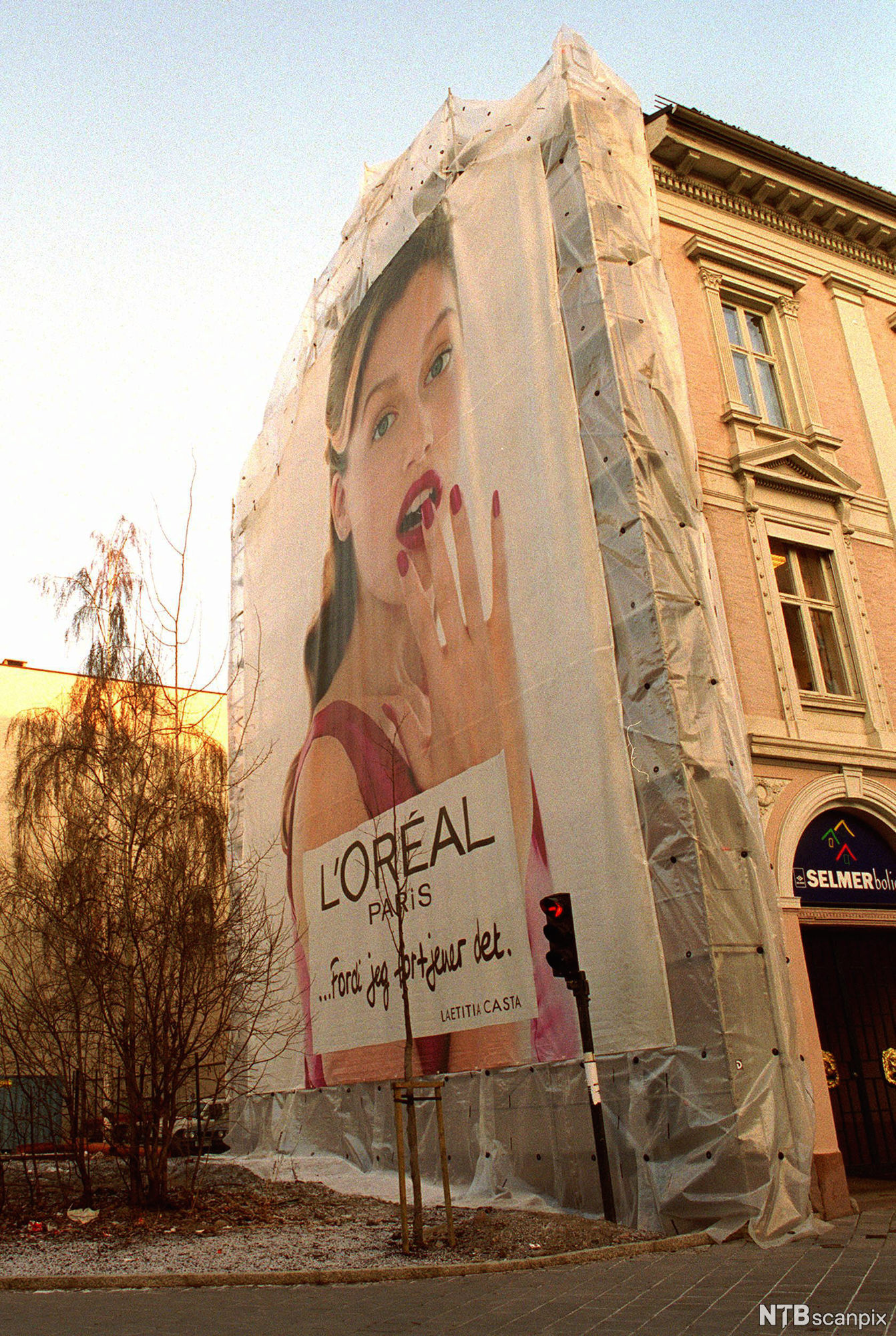 Reklameplakat fra L'Oreal på en husvegg. Foto.