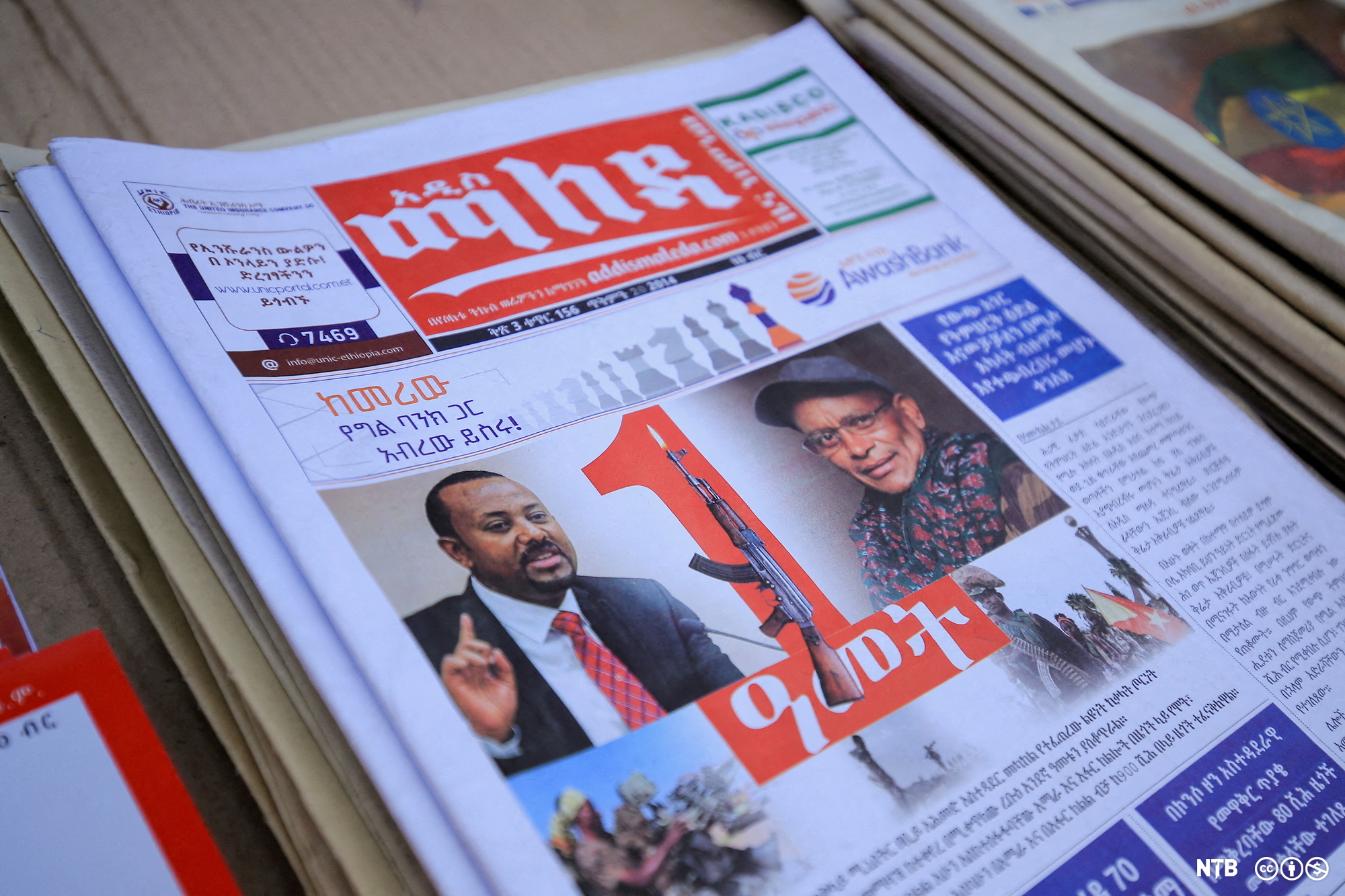 Portrettbilder av Etiopias statsminister Abiy Ahmed og leder av Tigray-folkets frigjøringsfront (TPLF) Debretsion Gebremichael på forsida av ei etiopisk avis. Statsministeren er avbildet i dress og slips, mens TPLF-lederen har kaps og skjerf. Mellom de to portrettene er det bilde av et gevær. Foto.