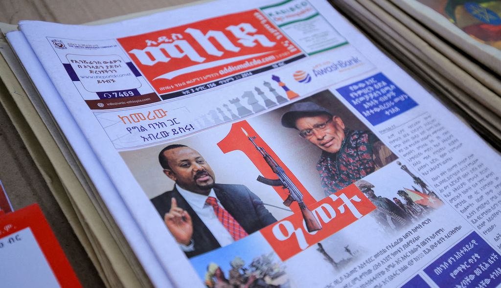 Portrettbilder av Etiopias statsminister Abiy Ahmed og leder av Tigray-folkets frigjøringsfront (TPLF) Debretsion Gebremichael på forsida av ei etiopisk avis. Statsministeren er avbildet i dress og slips, mens TPLF-lederen har kaps og skjerf. Mellom de to portrettene er det bilde av et gevær. Foto.