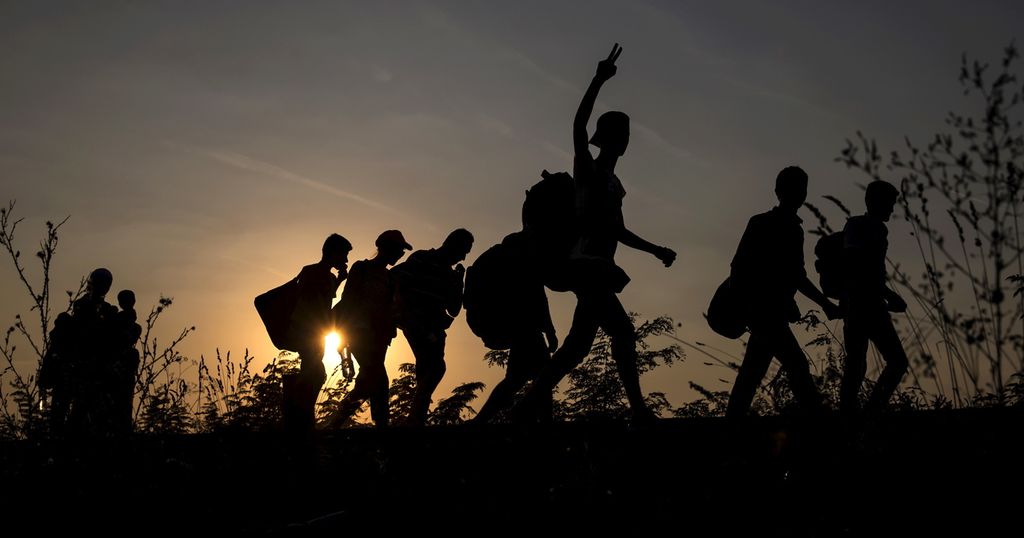 Silhouettes of eight migrants crossing into Hungary. Photo.