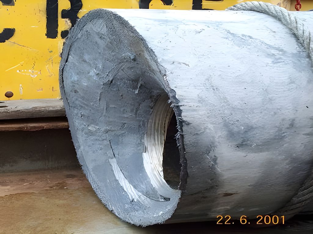 Tre dimensjoner casing som står inni hverandre. De er kuttet og trukket ut av en brønn. På utsida av de to indre casingene ser vi sementen som blir brukt til å feste casing i brønnen. Foto.