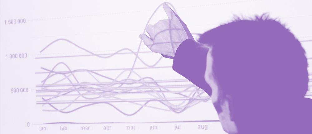 Mann peker i linjediagram som vises med en prosjektor. Foto.