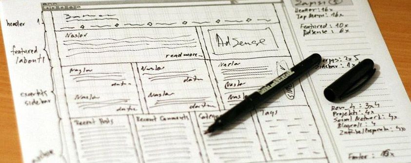 Nettside skissert opp på et papirark. En penn ligger oppå arket. Foto.