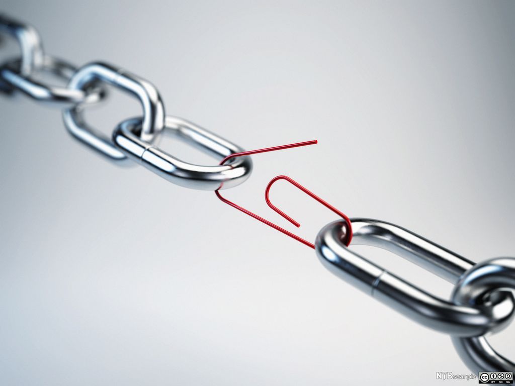 En rød binders er brukt som et ledd i en metallenke. Foto.