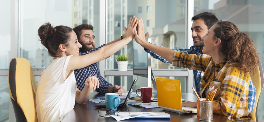 Fire personar som gir kvarandre ein high five. Foto.