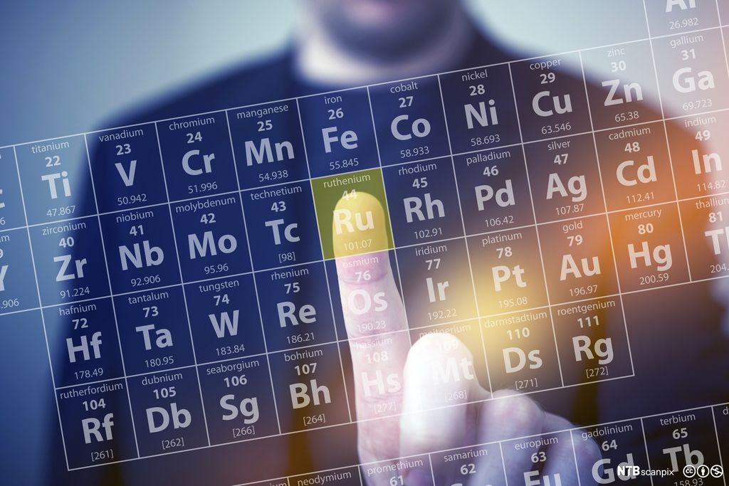 Pekefinger trykker på en liten rute. Foto.