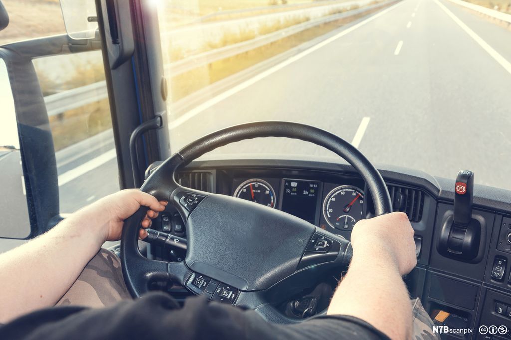 En sjåfør kjører en lastebil. Bilde.