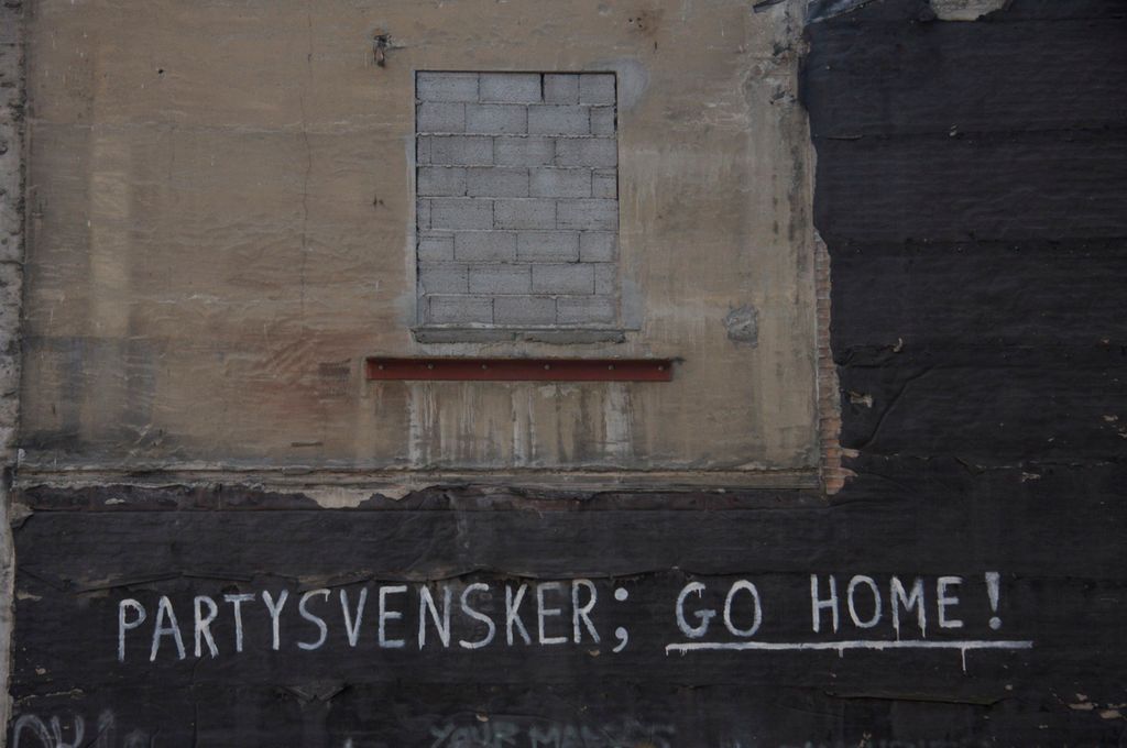 Murvegg med en tagget tekst som sier Partysvensker; go home! Foto.