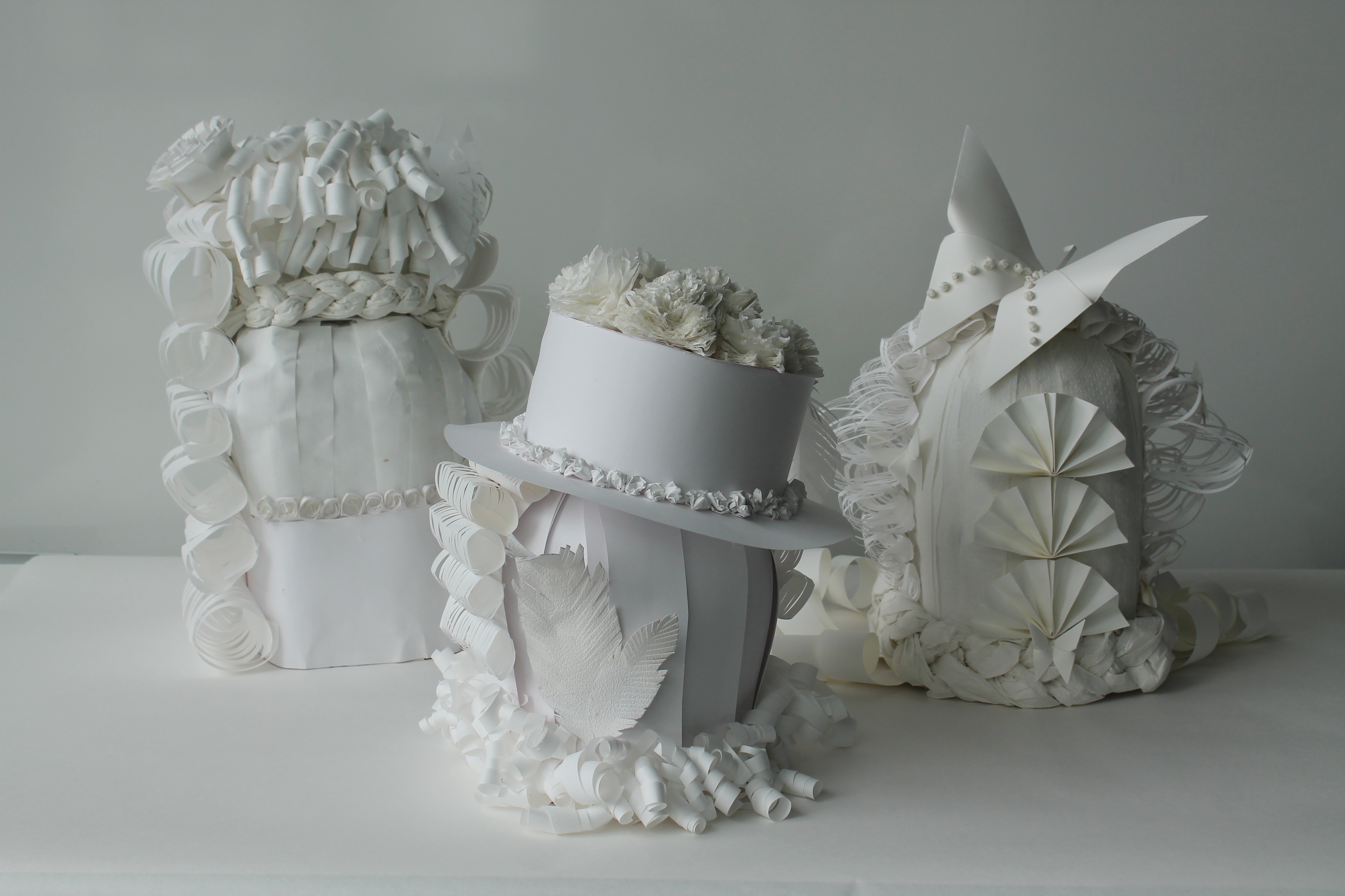 Tre dekorative parykker laget av papir. Foto.