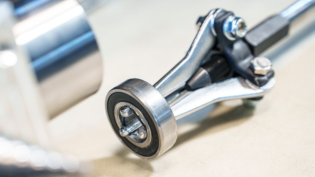 Et sylindrisk verktøy med tre bein festa i et lager. Foto.