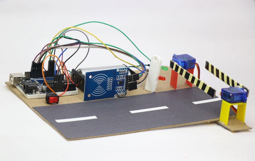 Arduinoprosjekt med en prototype av et automatisk bompengeinnkrevingssystem med RFID-sensor og servo. Alle elementene er plassert på et firkanta stykke papp i A4-størrelse. Foto.