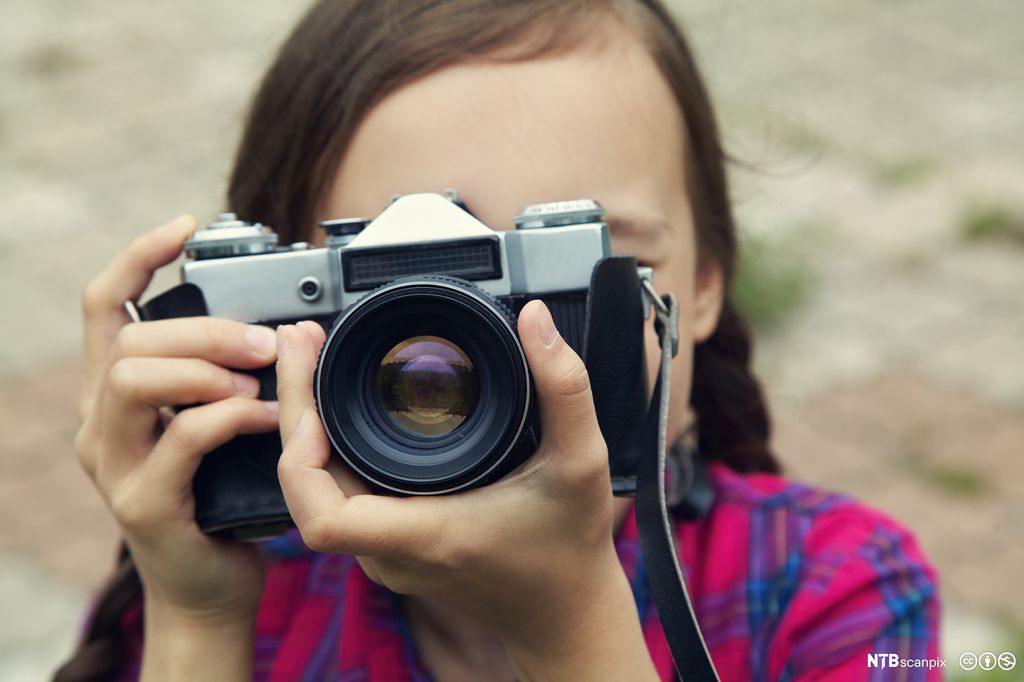 To hender som holder et fotoapparat. Fotografi.