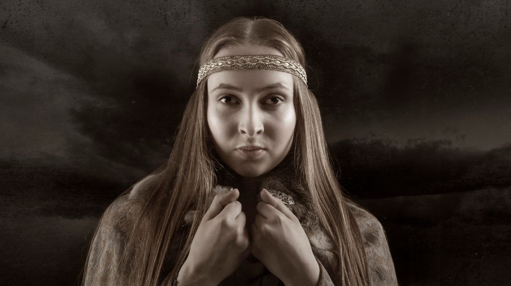 Halvnært portrett av en ung kvinne med kappe og hårbånd. Manipulert foto.