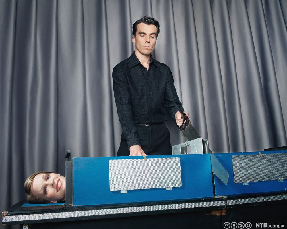 Magiker sager en dame i to. Foto.