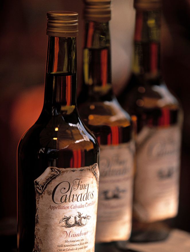 Tre flasker calvados med skrukork. Foto.