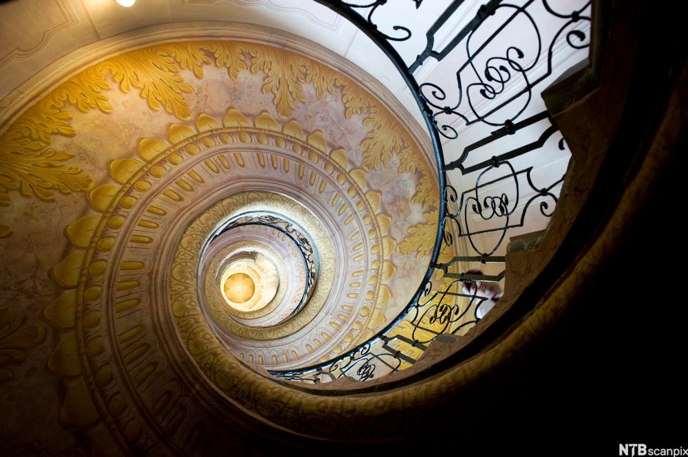 Spiraltrapp med barokke gelender og dekor, sett i froskeperspektiv. Foto.