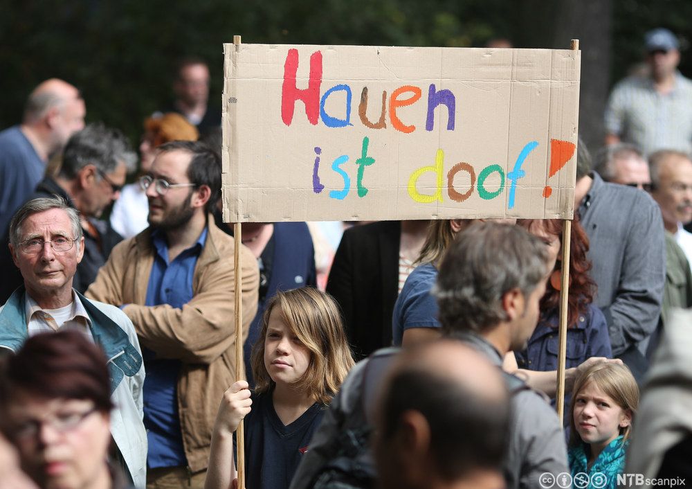 To barn deltar i en demonstrasjon og bærer en plakat med påskrifta Hauen ist doof. Foto.