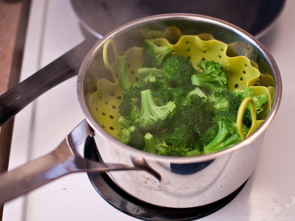 Kokt brokkoli i en kjele med damprist. Foto