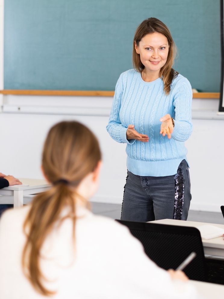 Lærer smiler til elev i klasserom. Foto.