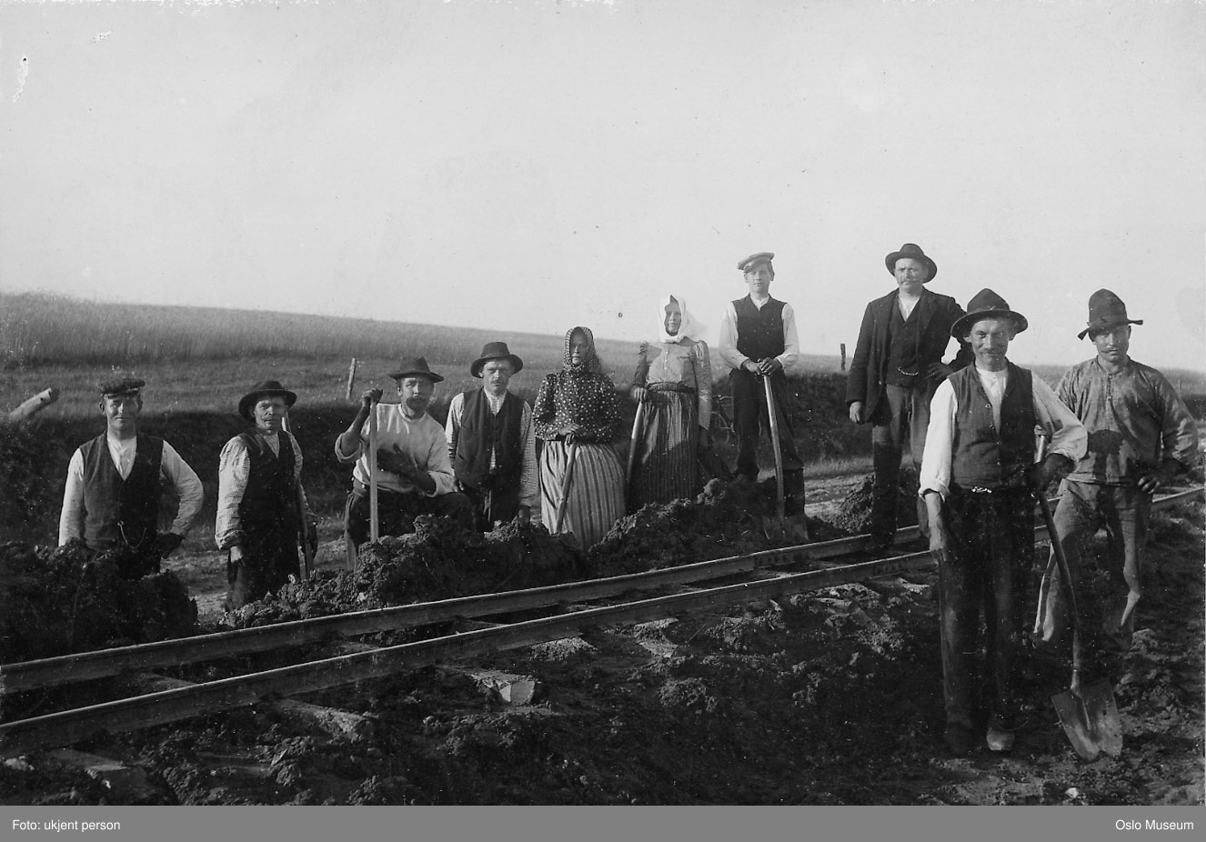Arbeidslag skinnelegg jernbane cirka år 1900. Det er åtte menn og to kvinner med på bildet. Foto.