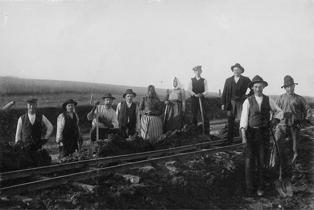 Arbeidslag skinnelegg jernbane cirka år 1900. Det er åtte menn og to kvinner med på biletet. Foto.