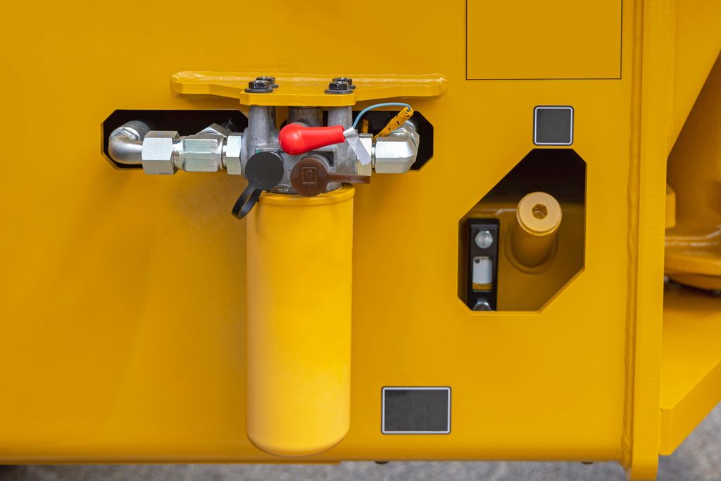 Stort, gult hydraulisk oljefilter hos Yellow Construction Machine. Foto.