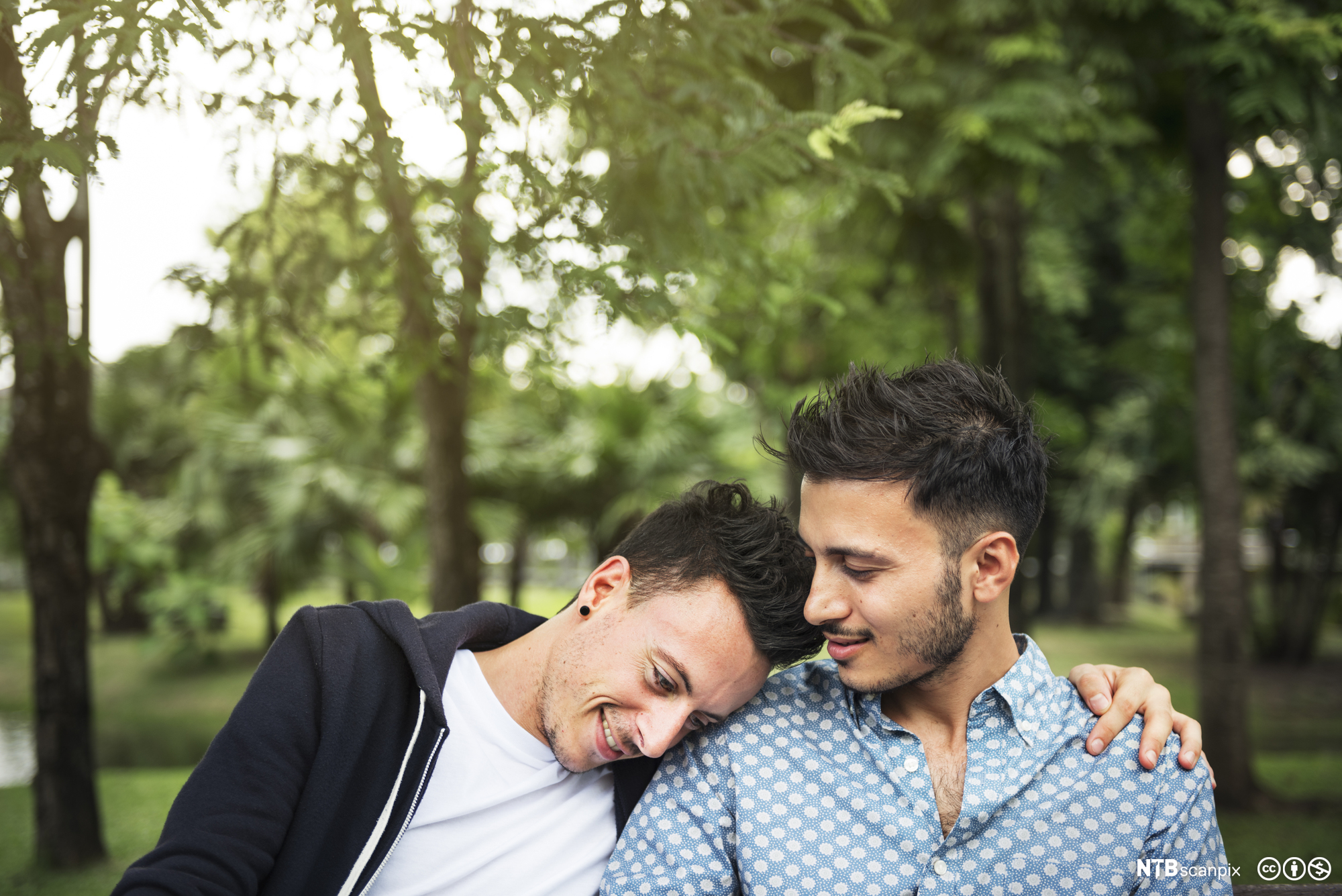 Homofilt par holder rundt hverandre. Foto.