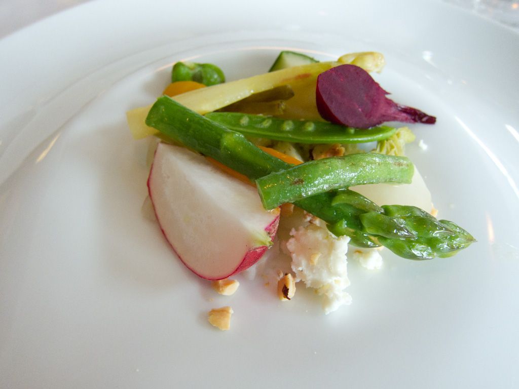 Tilberedte grønnsaker som asparges, sukkererter, reddik og rødbete pent anrettet på en tallerken. Foto.