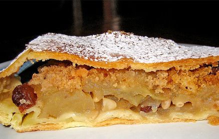 Eit stykke eplestrudel på ein tallerken. Foto.