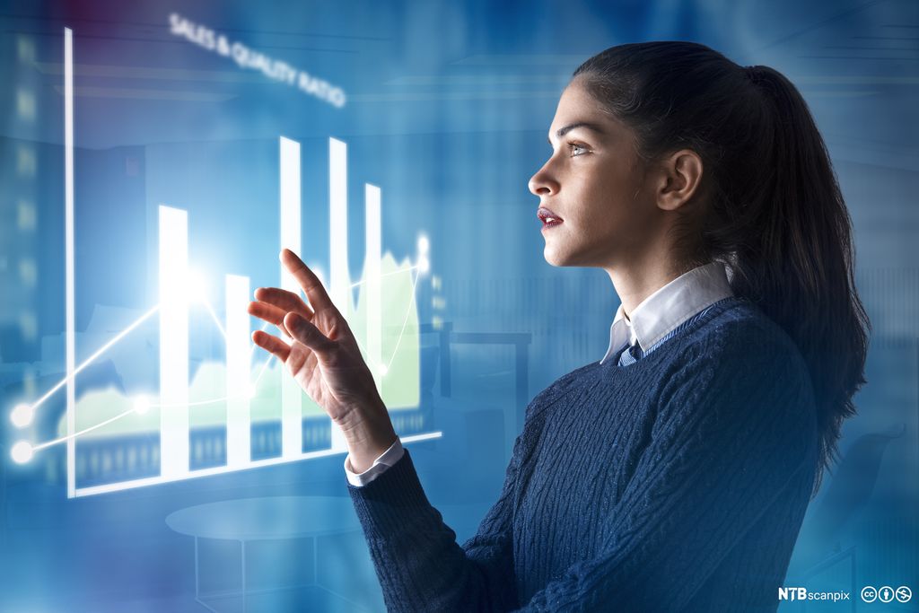 Foto av en ung kvinne som står foran en digital skjermvegg. Veggen viser et stolpediagram med forskjellige typer data. Illustrasjon.