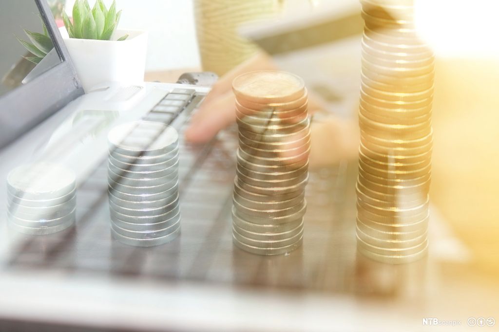 Dobbeleksponering av pengestabler og arbeid på datamaskin. Bilde.