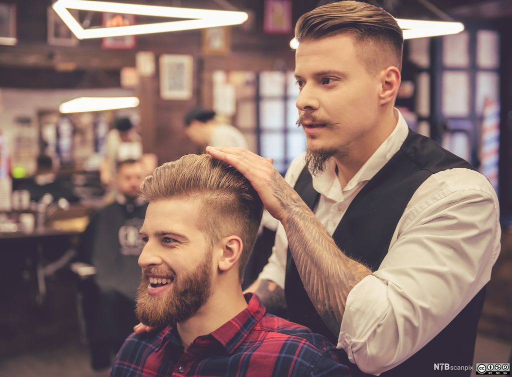 Smilende mannlig kunde hos frisør. Foto.
