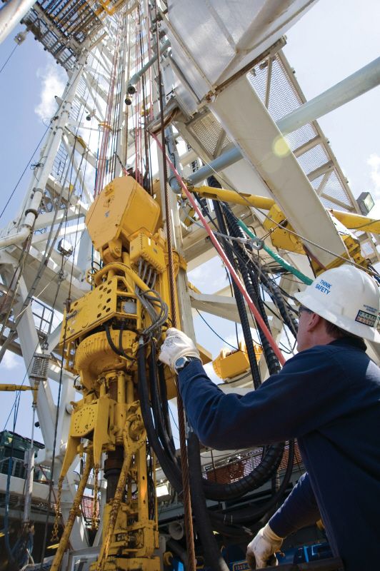 En arbeider ser opp mot boretårnet fra boredekket. Foto