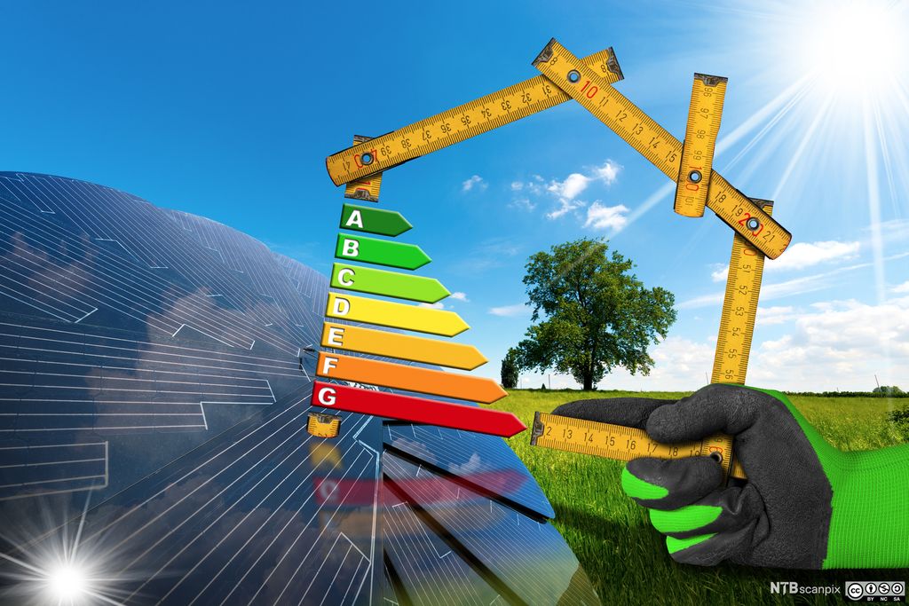 Person holder en tommestokk med en energikarakterskala bort til et solcellepanel. Manipulert foto.