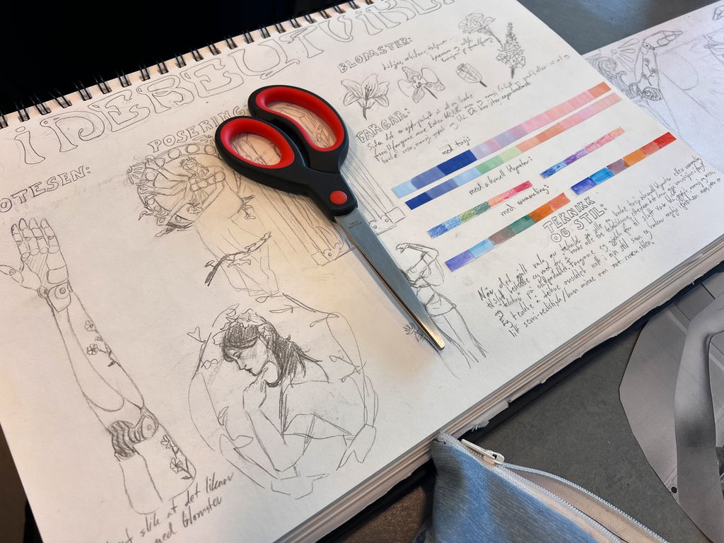 Tegninger, fargeprøver og tekst i ei skissebok. Foto.