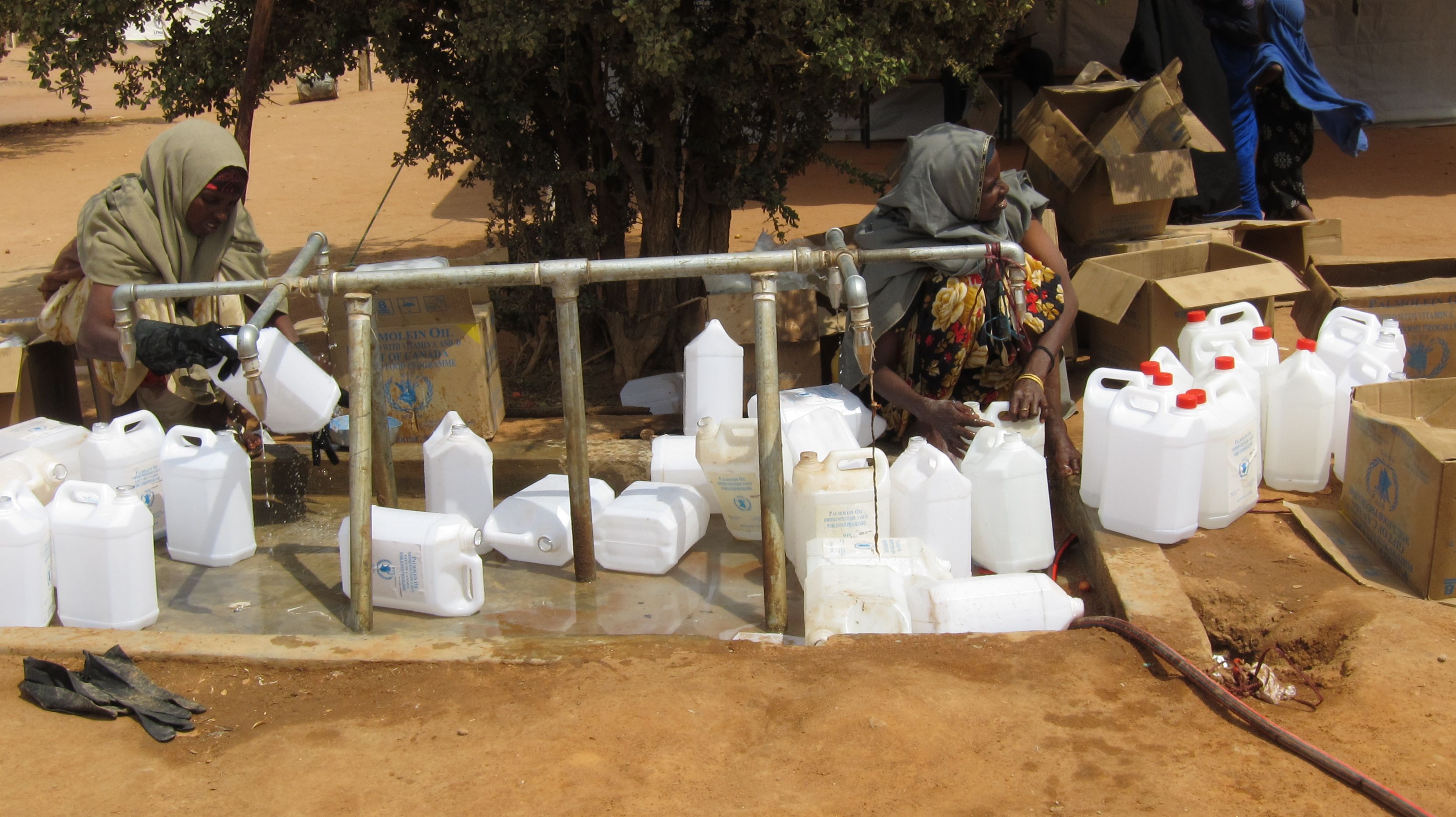Two women are collecting drinking water in a refugee camp on the Kenyan-Somali border. Photo.