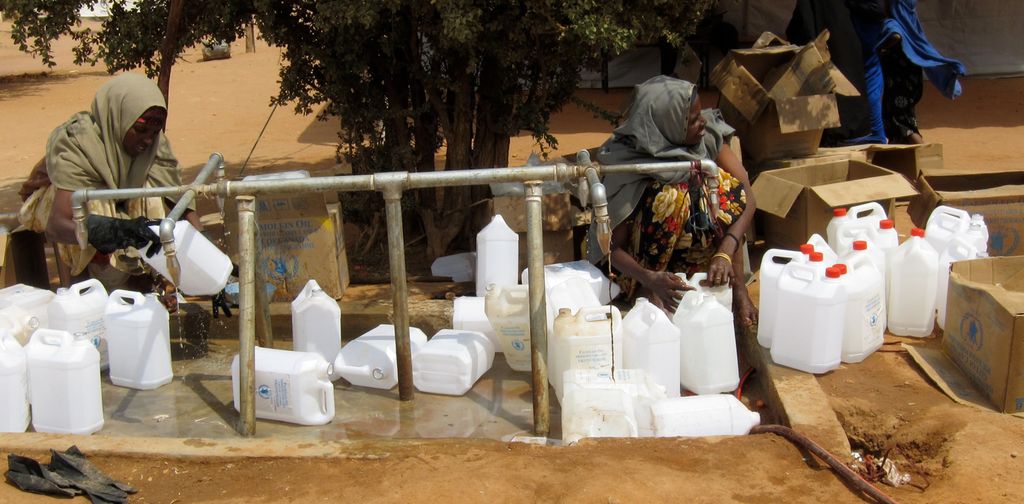 Two women are collecting drinking water in a refugee camp on the Kenyan-Somali border. Photo.