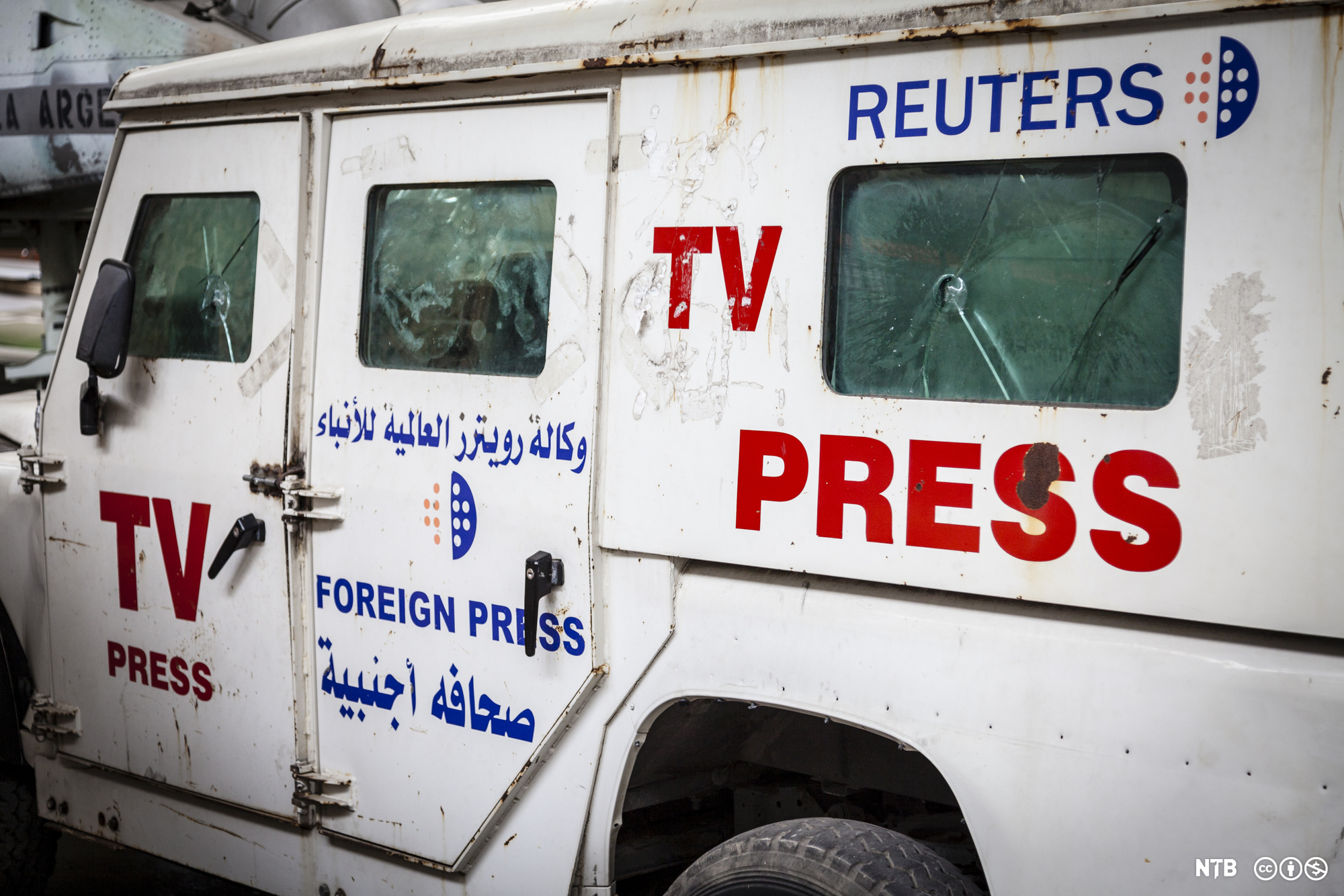 En rusten Land Rover har påmalt tekstene "TV press", "Foreign press" og "Reuters" med latinske og arabiske bokstaver. Foto.