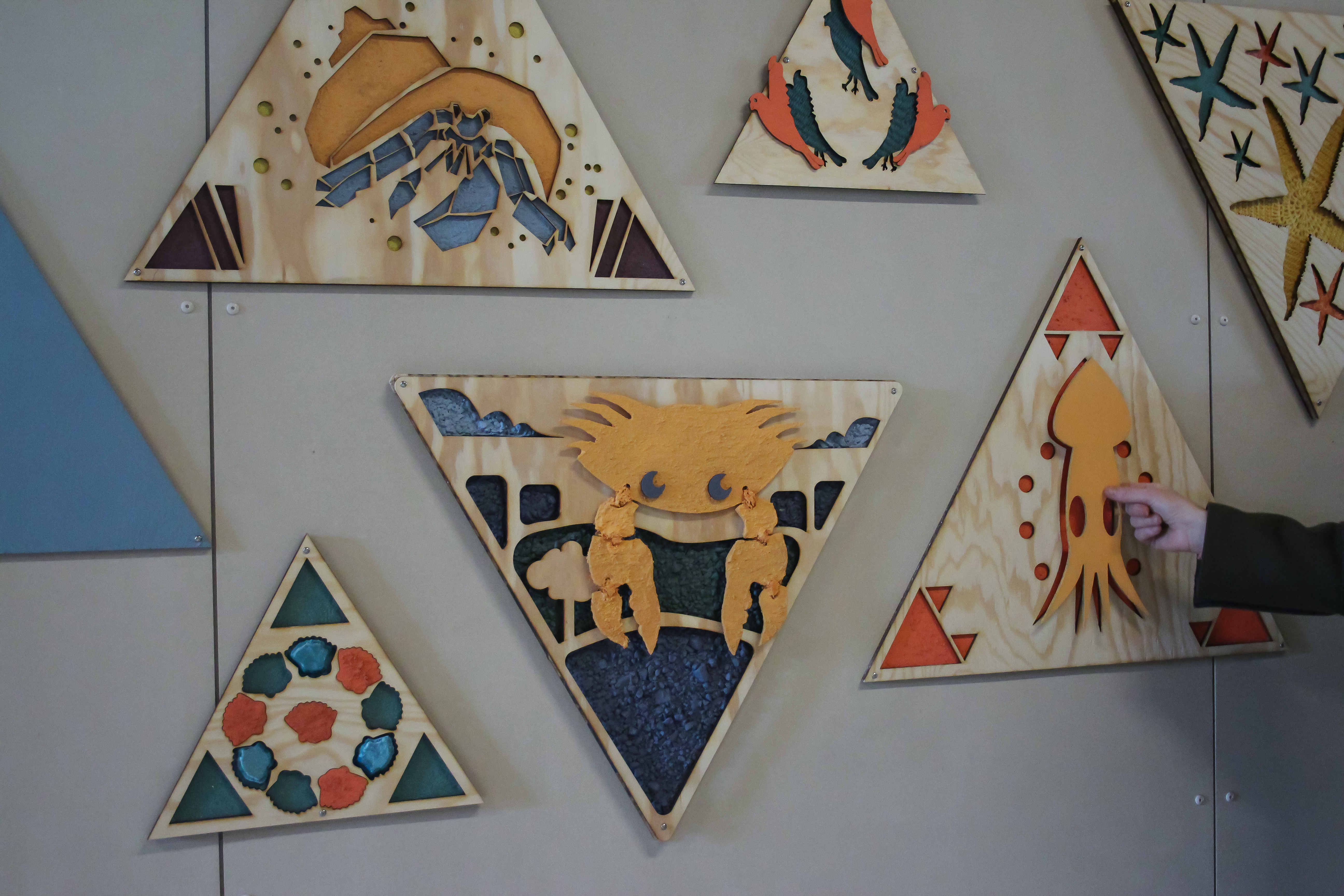 Tredimensjonale bilder i taktile materialer på en vegg. Foto. 