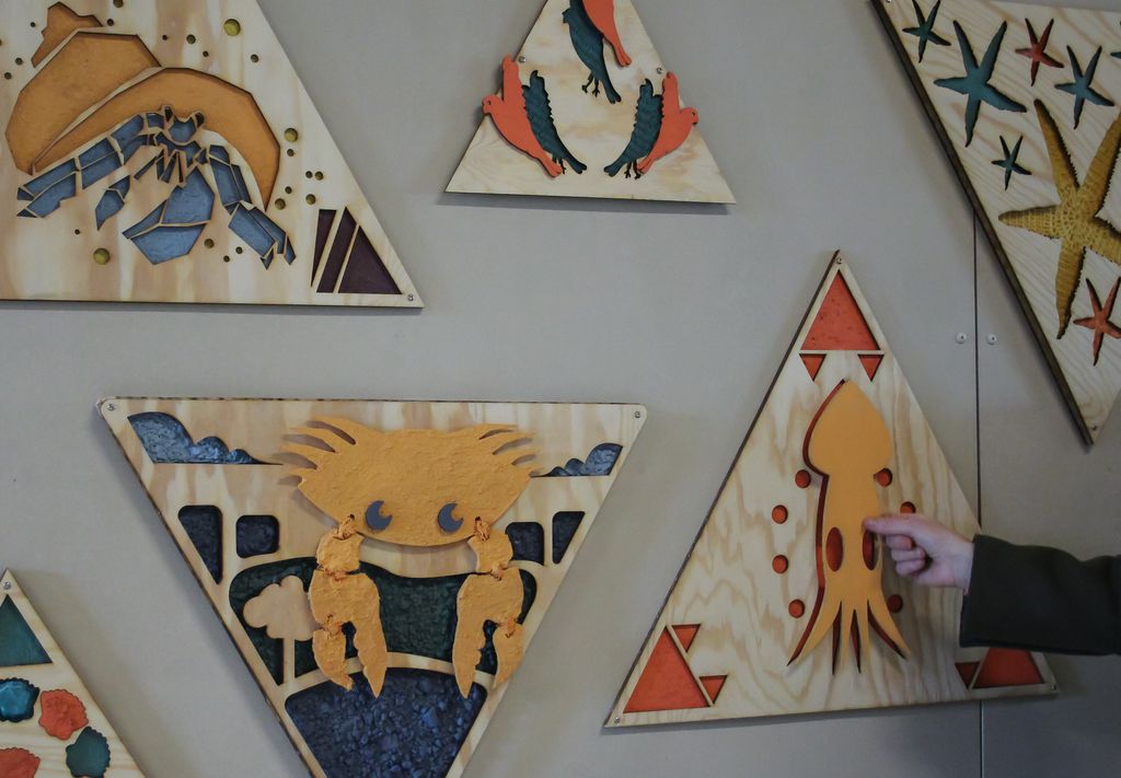 Tredimensjonale bilder i taktile materialer på en vegg. Foto.