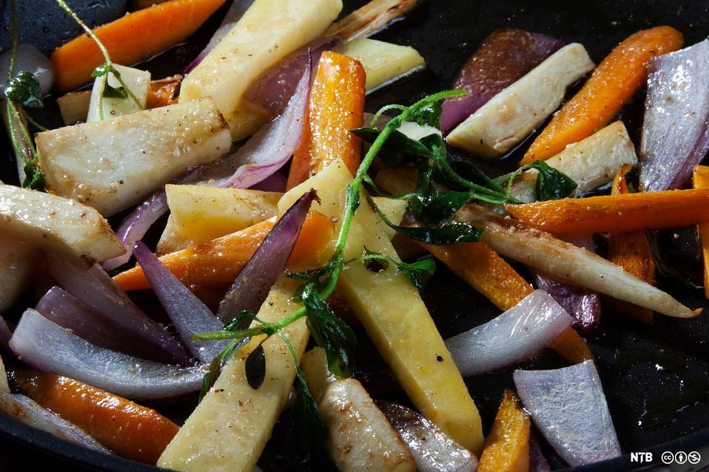 Ovnsbakte rotgrønnsaker, rødløk og frisk timian. Foto.