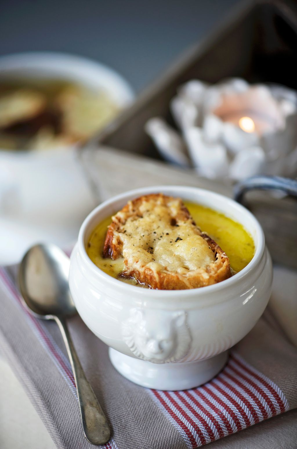 Lauksuppe med ei brødskive med gratinert ost i ein bolle. Foto.