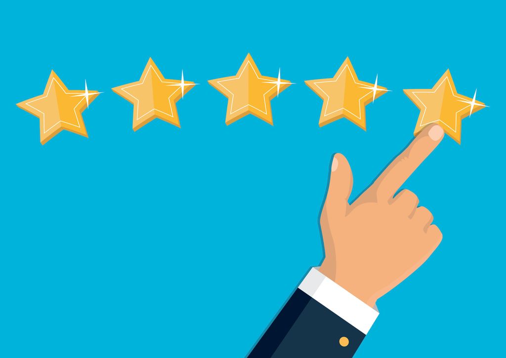 Hånd peker med finger mot fem gule stjerner. Foto.