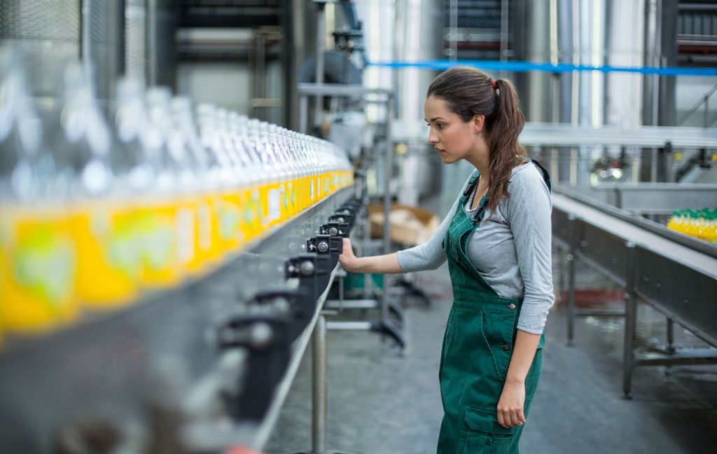 Ei kvinne overvaker ei produksjonslinje. Foto.