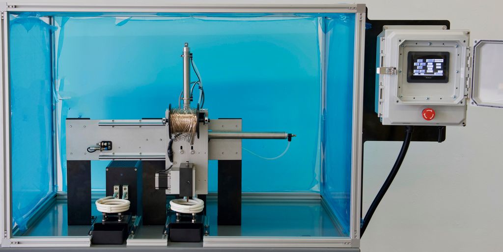 Maskin med en skjerm i et glasskabinett. Det er to spoler på maskinen. Foto.