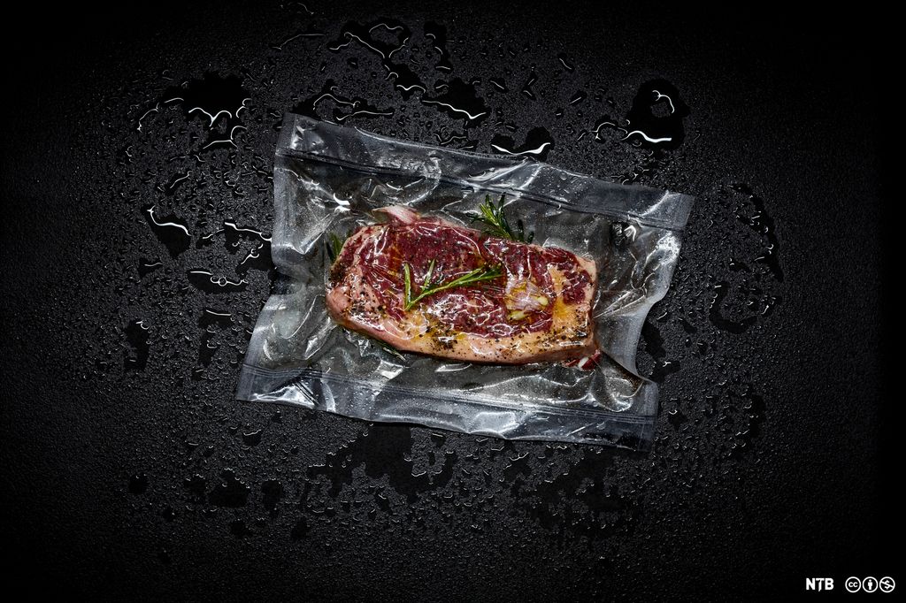Et stykke oksekjøtt med urter i en vakuumpose. Foto.
