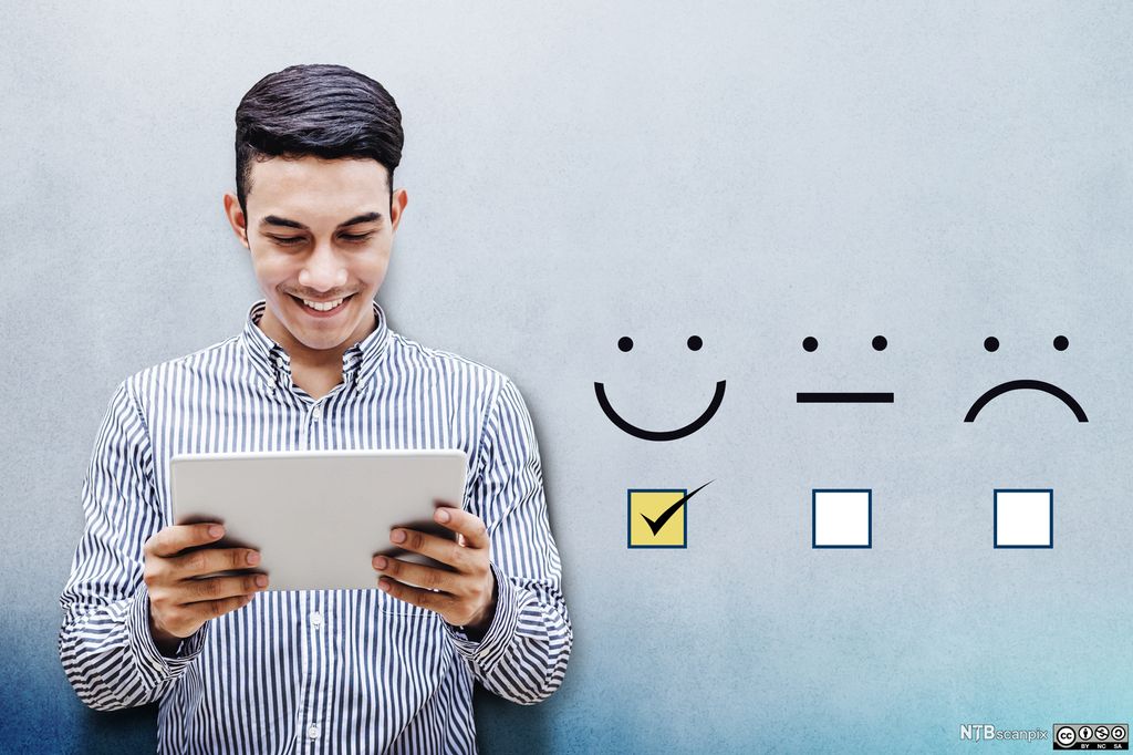 En ung mann ser smilende på et nettbrett. Ved siden av ham er det illustrert et smilefjes, et nøytralt fjes og et surt fjes med avmerkingsbokser under, og det er huket av i boksen under smilefjeset. Illustrasjon.